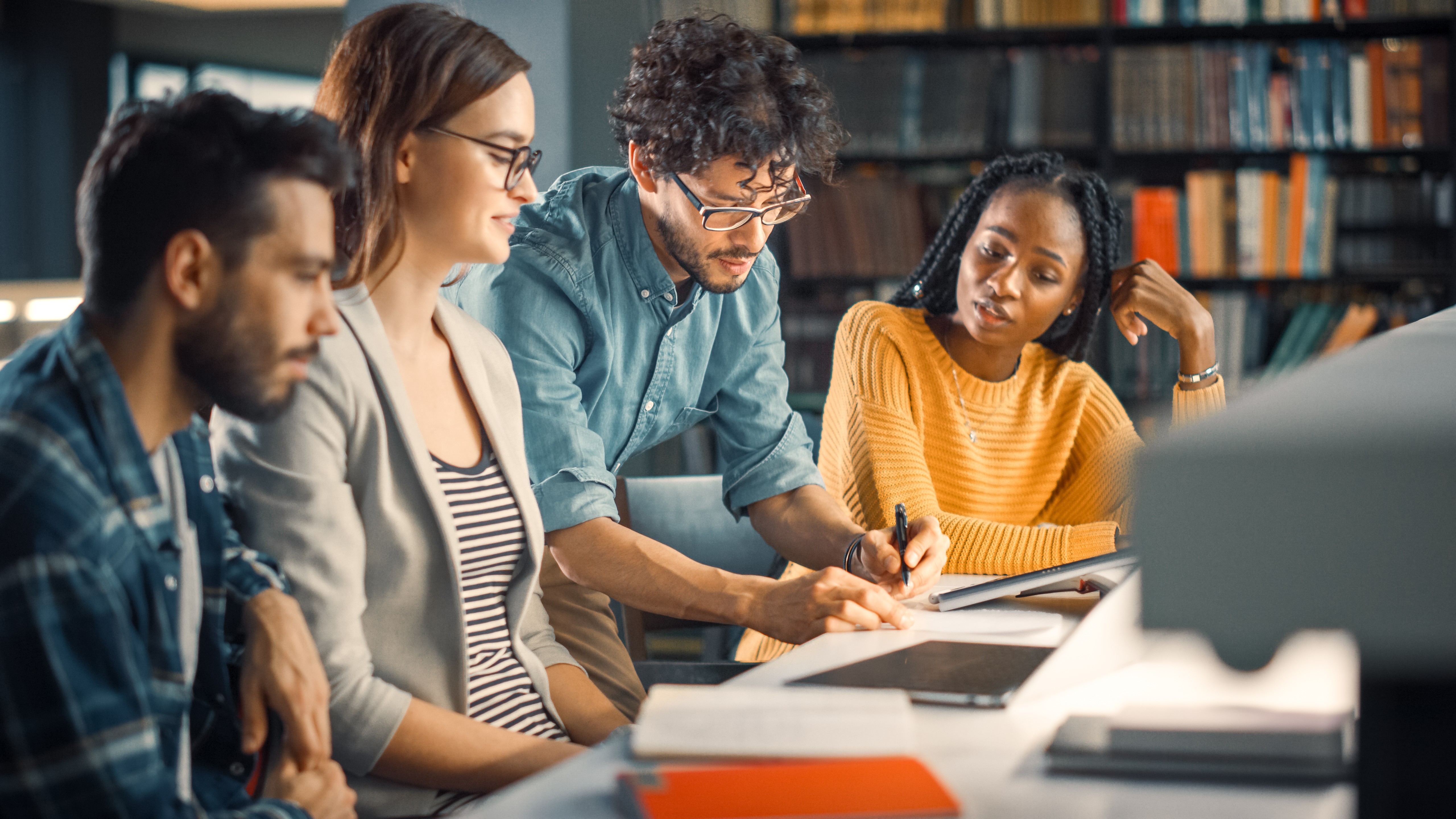 Masterstudierende der Hochschule, die interessiert um eine Zeichnung stehen.